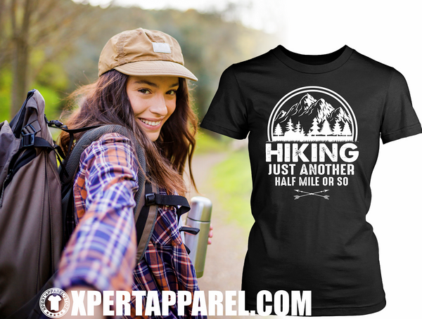 Woman Taking selfie as she goes 'Hiking" Black T-shirt mock-up off to the side with "Hiking, just another half mile or so" design on the front. available from the Xpert Apparel Store.