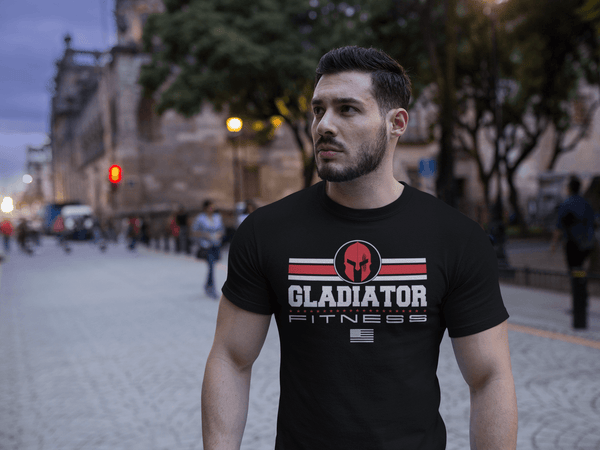 Muscular Guy walking the streets outdoor wearing Black T-shirt with Gladiator Fitness Logo design red and white on the front Available from the Xpert Apparel Store.