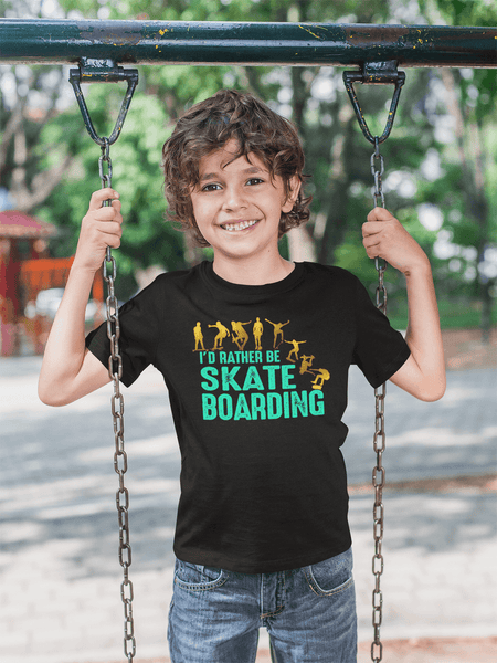 Kid standing on a swing wearing T-shirt with I'D  Rather Be Skate Boarding design available from the Xpert Apparel Store