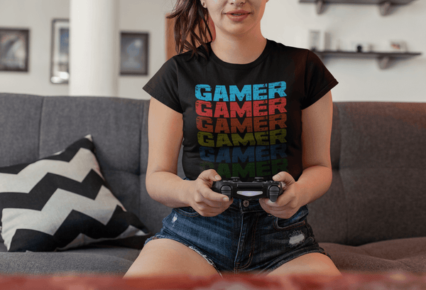 Front View of girl sitting on couch playing video games wearing Black T-shirt with Faded Out Gamer design from the Xpert Apparel Store 