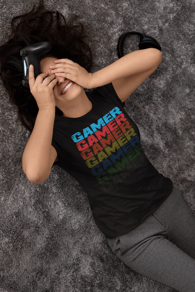 Girl playing Video game laying on floor with hands over face wearing black T-shirt with Faded Out Gamer Design from the Xpert Apparel Store