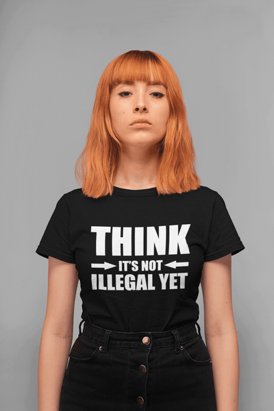 Woman standing with gray background, red hair wearing a black T-shirt "Think It's not Illegal Yet" in white letters from the Xpert apparel store