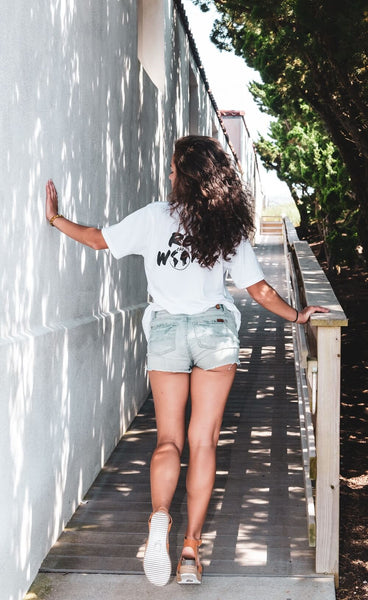 A girl in short jeans shorts on walkway wearing Rep world t-shirt