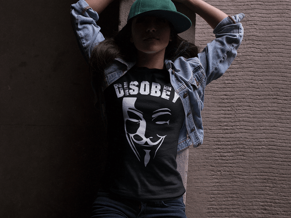 Girl in Jeans Jacket and Black T-shirt with Vendetta Mask Disobey Design  from the Xpert Apparel Store 